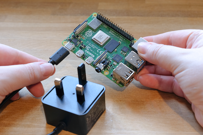Plugging a power supply into a Raspberry Pi.