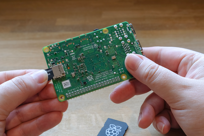 Inserting a microSD card into a Raspberry Pi.